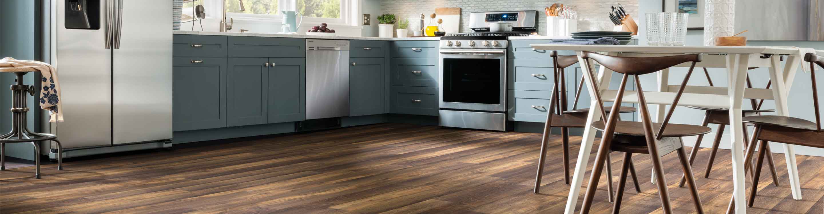 Wood look vinyl flooring in a kitchen with blue cabinetry